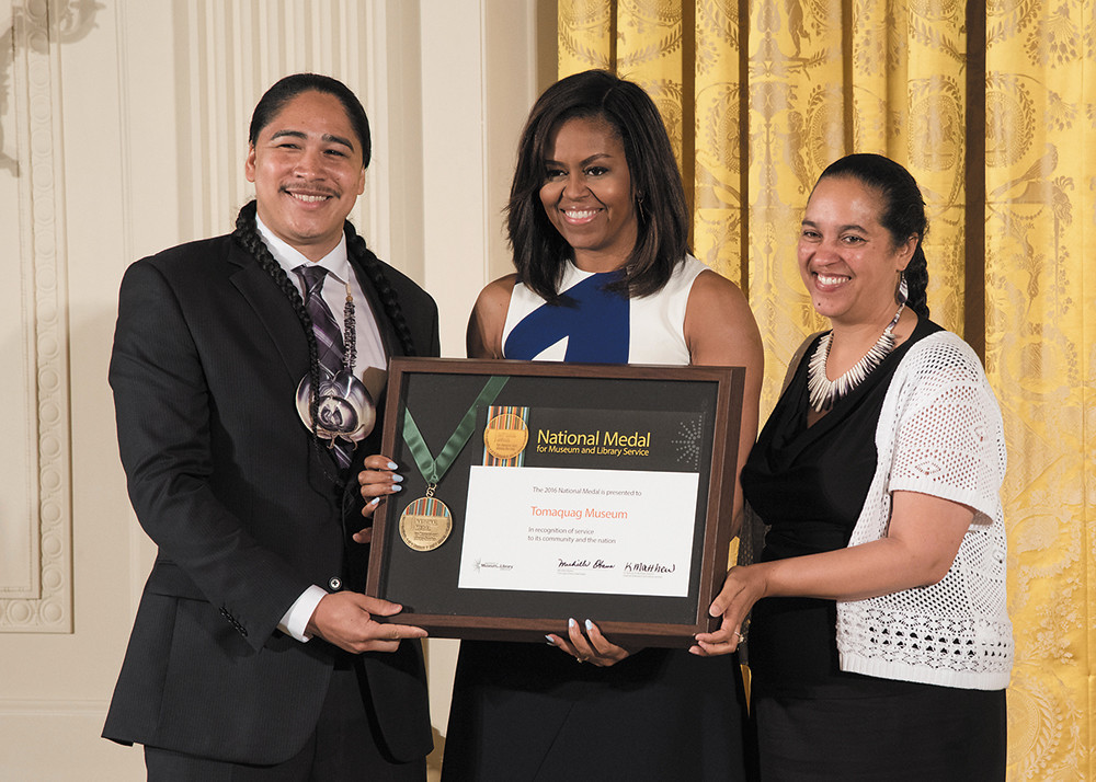 First Lady Michelle Obama presented the 2016 National Medal for Museum and Library Service to the Tomaquag Museum's Executive Director Loren Spears (pictured right) and Christian Hopkin (pictured left)