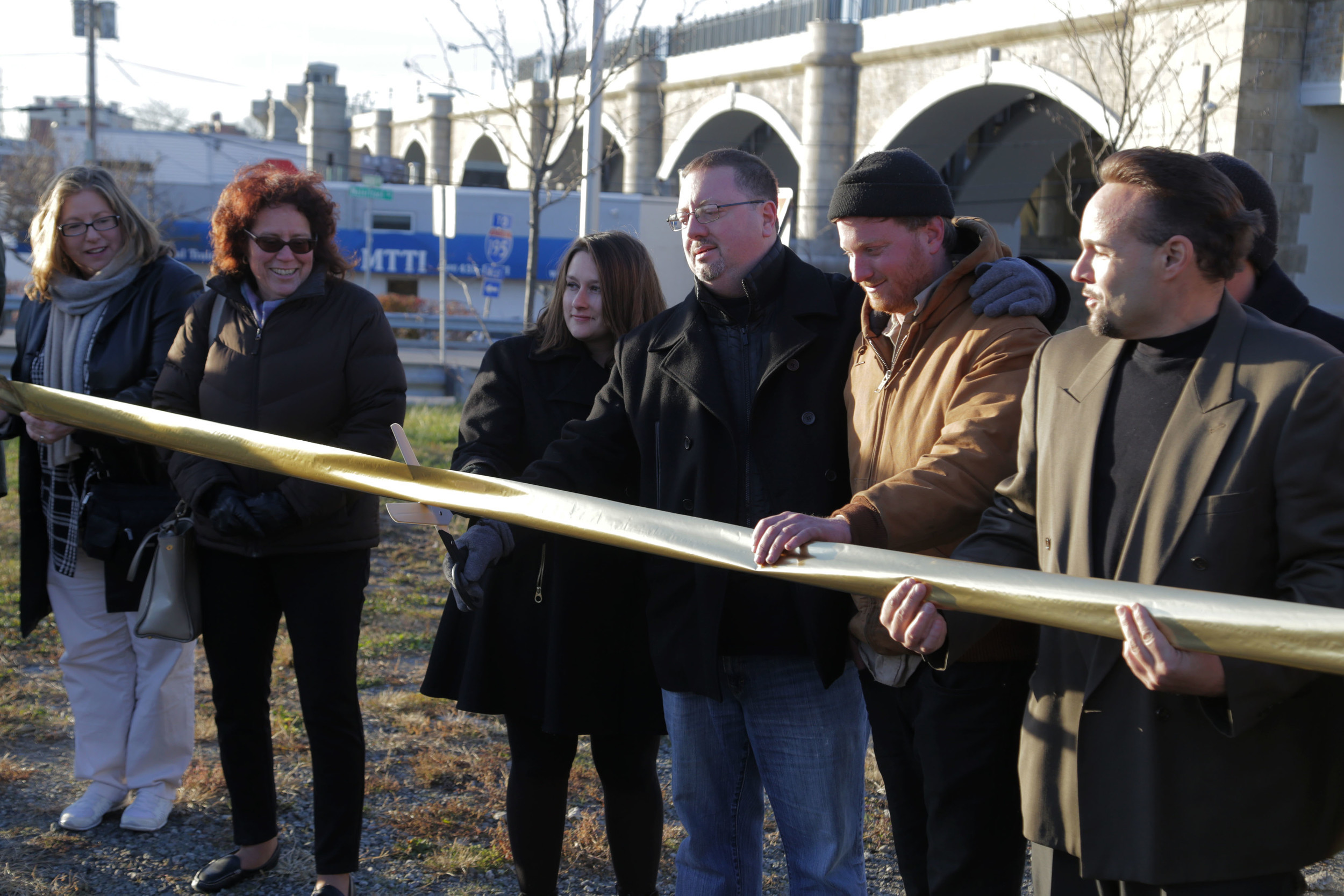 Members of the East Providence Arts Council cut a ribbon in front of the new sculpture "Rigging" located in the new Watchemocket Square.