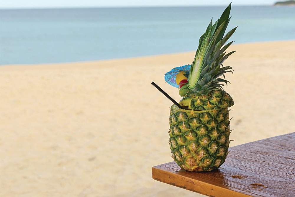 Summer perfection is a cocktail in a pineapple at Ballard's Beach