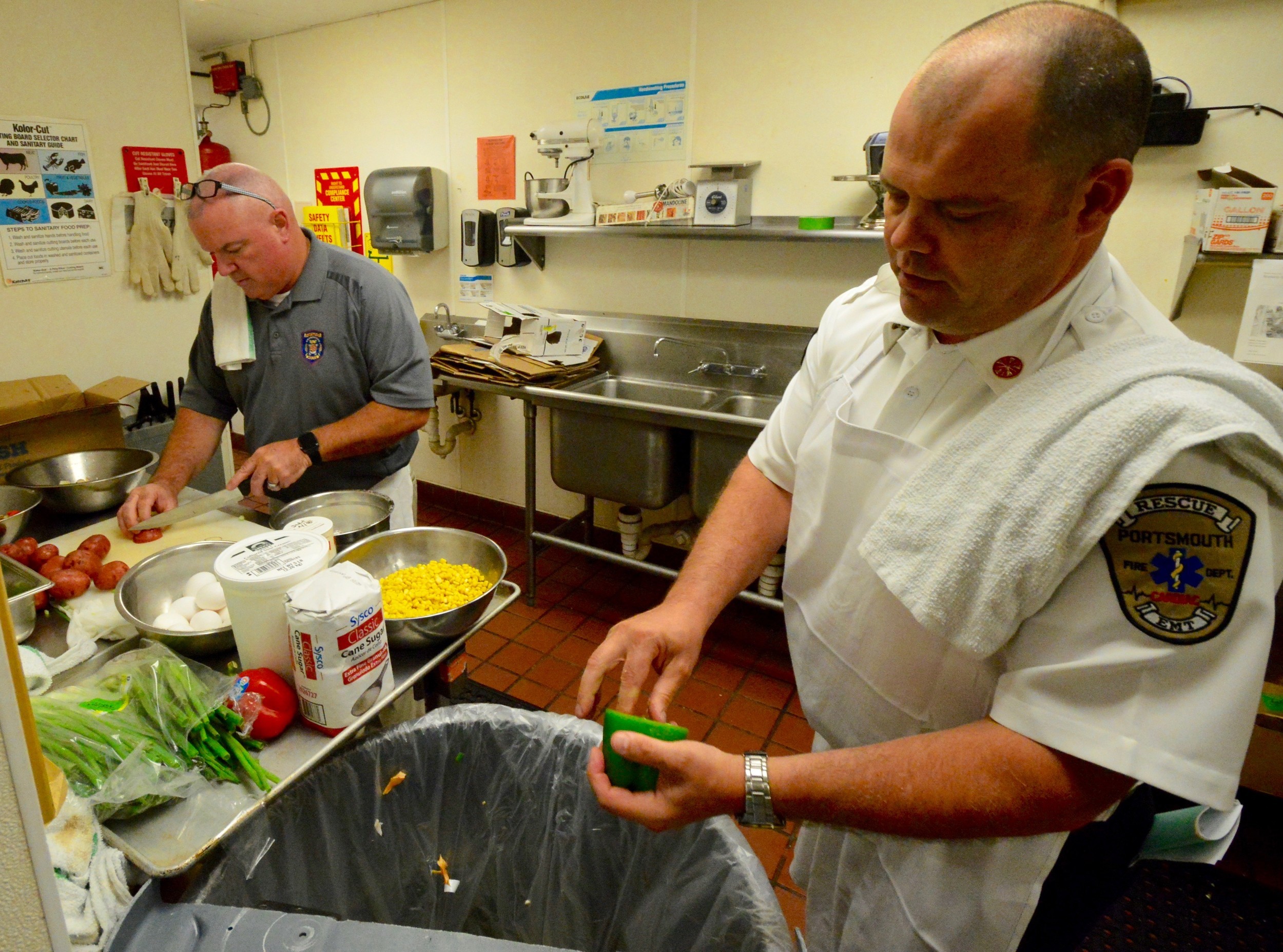 Patrolman Jack Clarke (left) works on his dish while Fire Chief Michael Cranson seeds a green pepper.