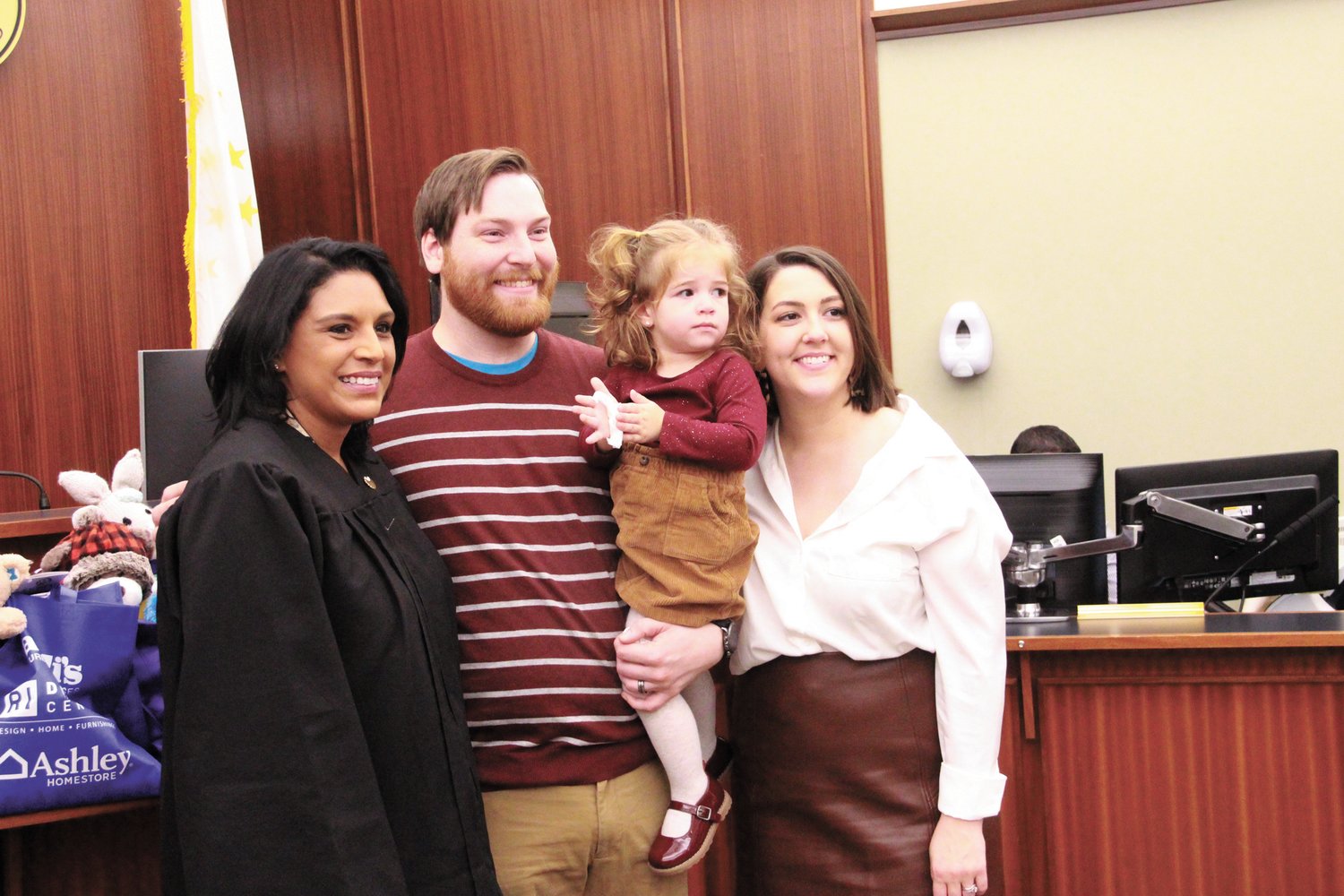 PHOTO OP: Jeffrey Ferrara holds daughter Kiana as he and his wife Allison pose with Associate Justice Elizabeth Ortiz following the adoption proceedings.