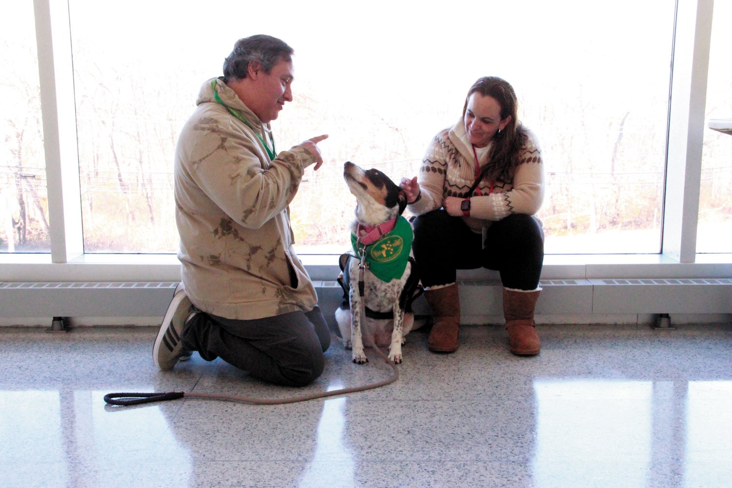 COURT MANNERS: Mia the cattle dog obeys trainer Carlos Moriella’s commands with July DeSousa. Carlos Moriella’s company Soul Therapy Dogs helped comfort children and families during the adoption process.