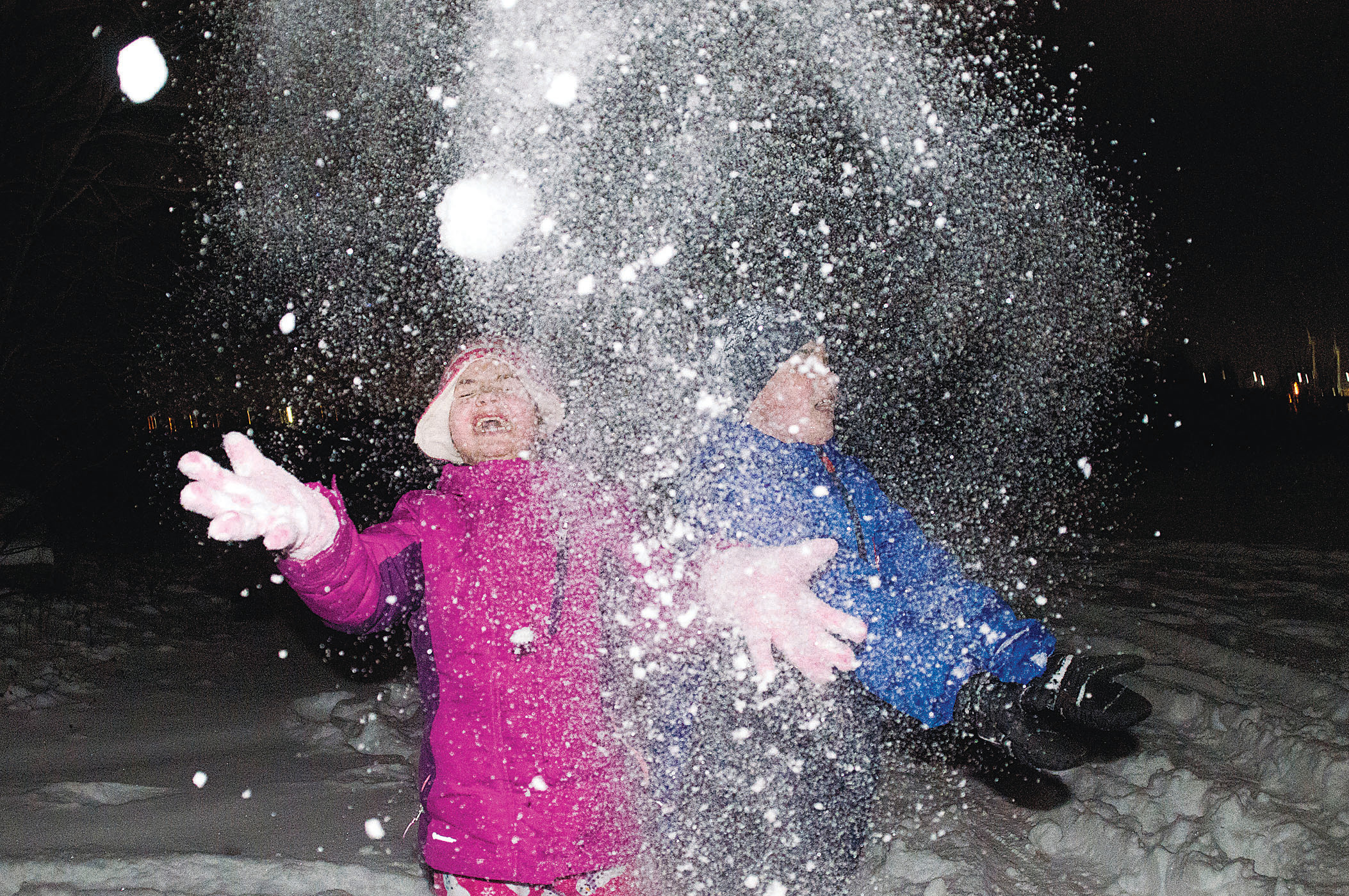 Gessalyn Dias and Jaden McAdam throw snow on the East Bay Bike Path behind the Squantum Club in Riverside after shining lights at Hasbro Children’s Hospital Monday night.