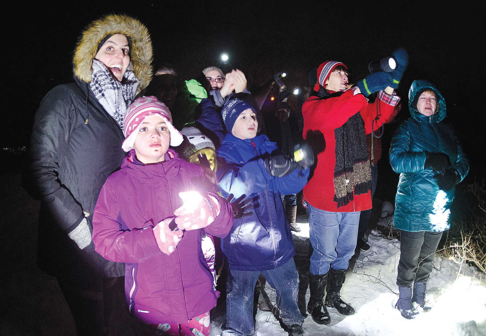 Jess Calderone (left), daughter Gessalyn Dias and nephew Jaden McAdam join a group from Bristol’s First Congregational Church in shining “Good Night Lights” at Hasbro Children’s Hospital Monday.