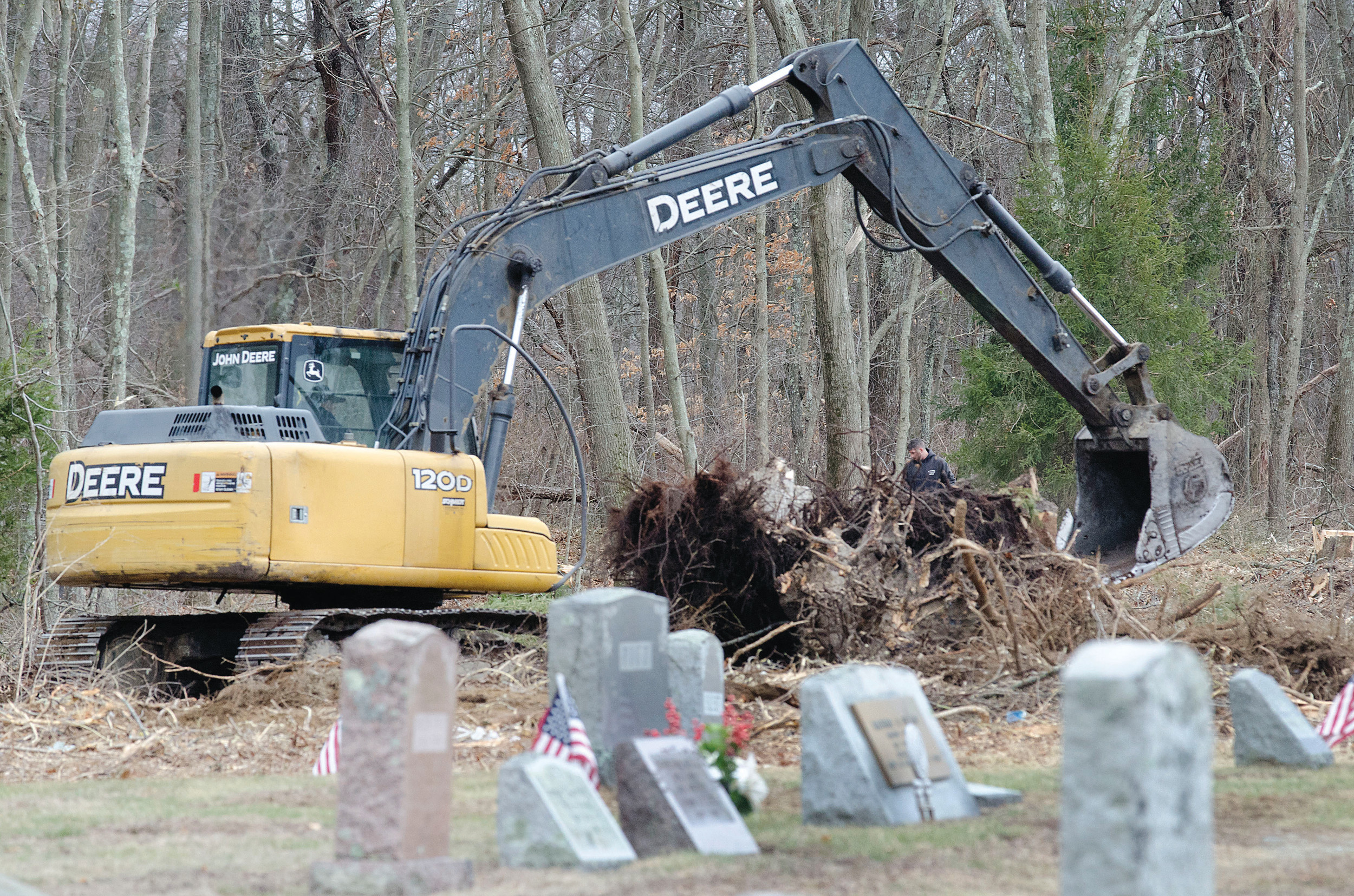 Workers dig in at a wooded area at the east end of the South Burial Ground in Warren Tuesday.