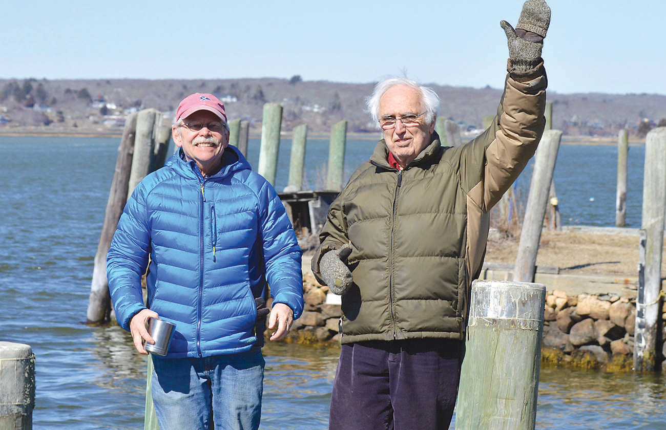 Jim Whitin, chairman of the Westport Planning Board, and David Cole of the Westport Watershed Alliance stand on town docks that are predicted to be deep underwater by century’s end.  Tides would rise above Mr. Cole’s outstretched arm. The two have launched the South Coast Climate Change Coalition in hopes of helping prepare for the changes to come.