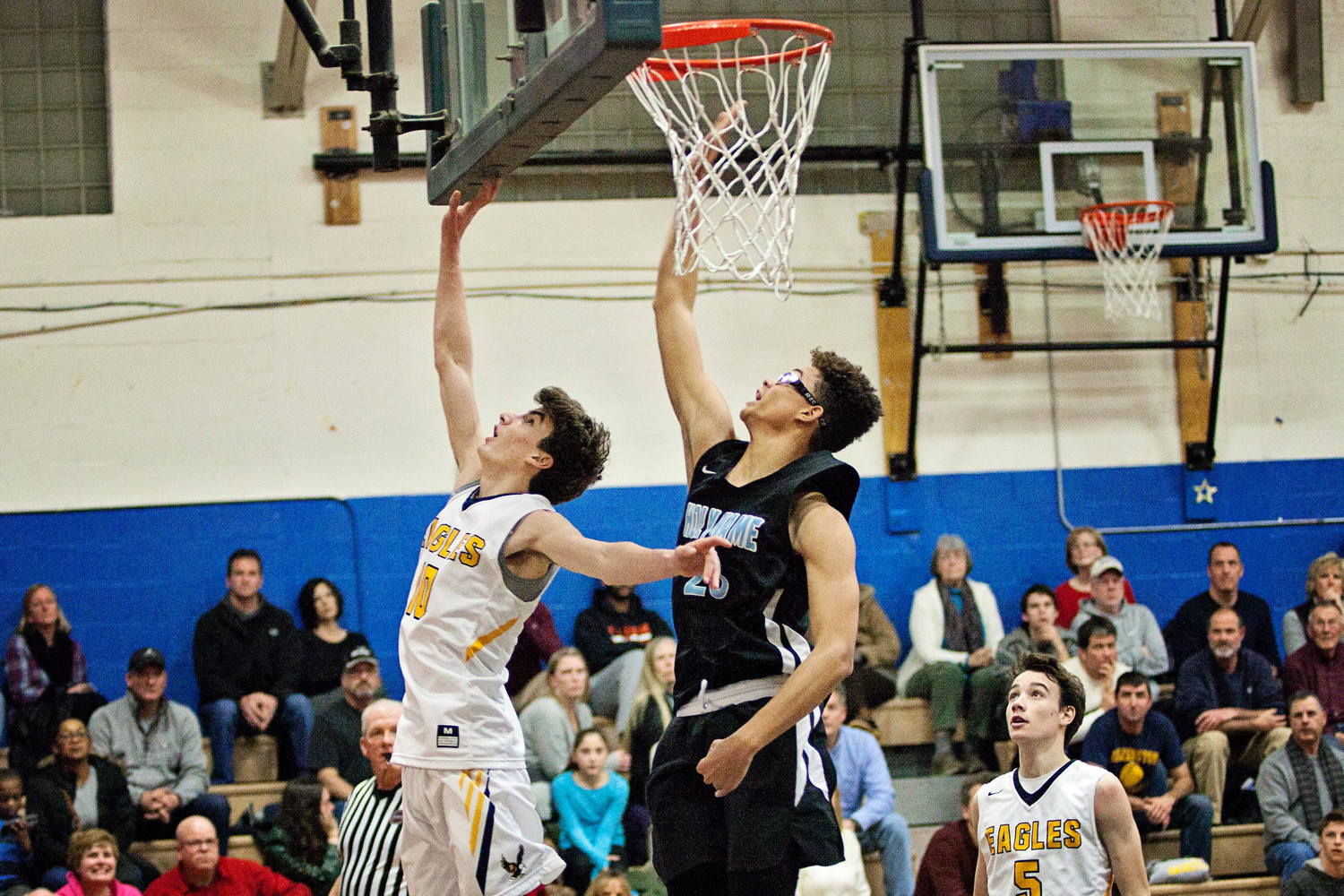 Ryan Bonneau lays the ball up while a Holy Name player tries to block the shot.