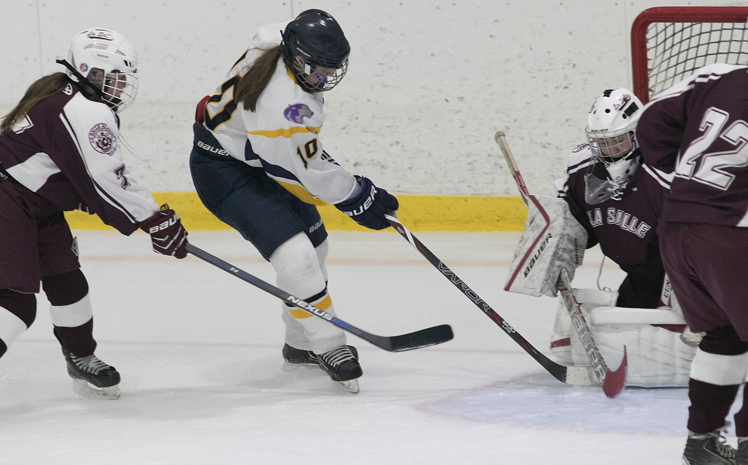 Junior defenseman Madelyn Cox stuffs the puck by La Salle goaltender Asia Porter to tie the score late in the third period.